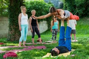 Partner- Yoga auf der Wiese